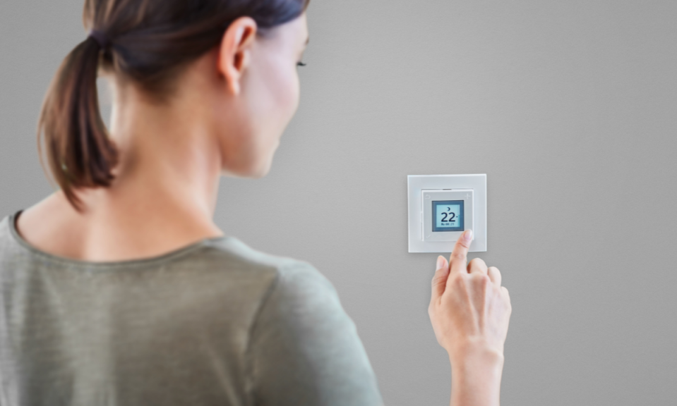 Frau stellt Temperatur Smart Home System ein