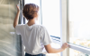 Frau öffnet Fenster zum Lüften