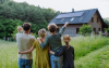 Familie vor Haus mit PV